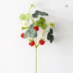 Fraises artificielles en arrangement floral coloré